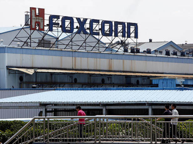 Workers walk outside Hon Hai Group's Foxconn plant in Shenzhen, Guangdong province, China, on Wednesday, May 26, 2010. Gou said nine of the 11 company workers who either committed suicide or attempted to had worked at the company less than a year, and six had been employed for less than a half-year. Photographer: Qilai Shen/Bloomberg